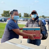 Volunteer handing out a box of food.